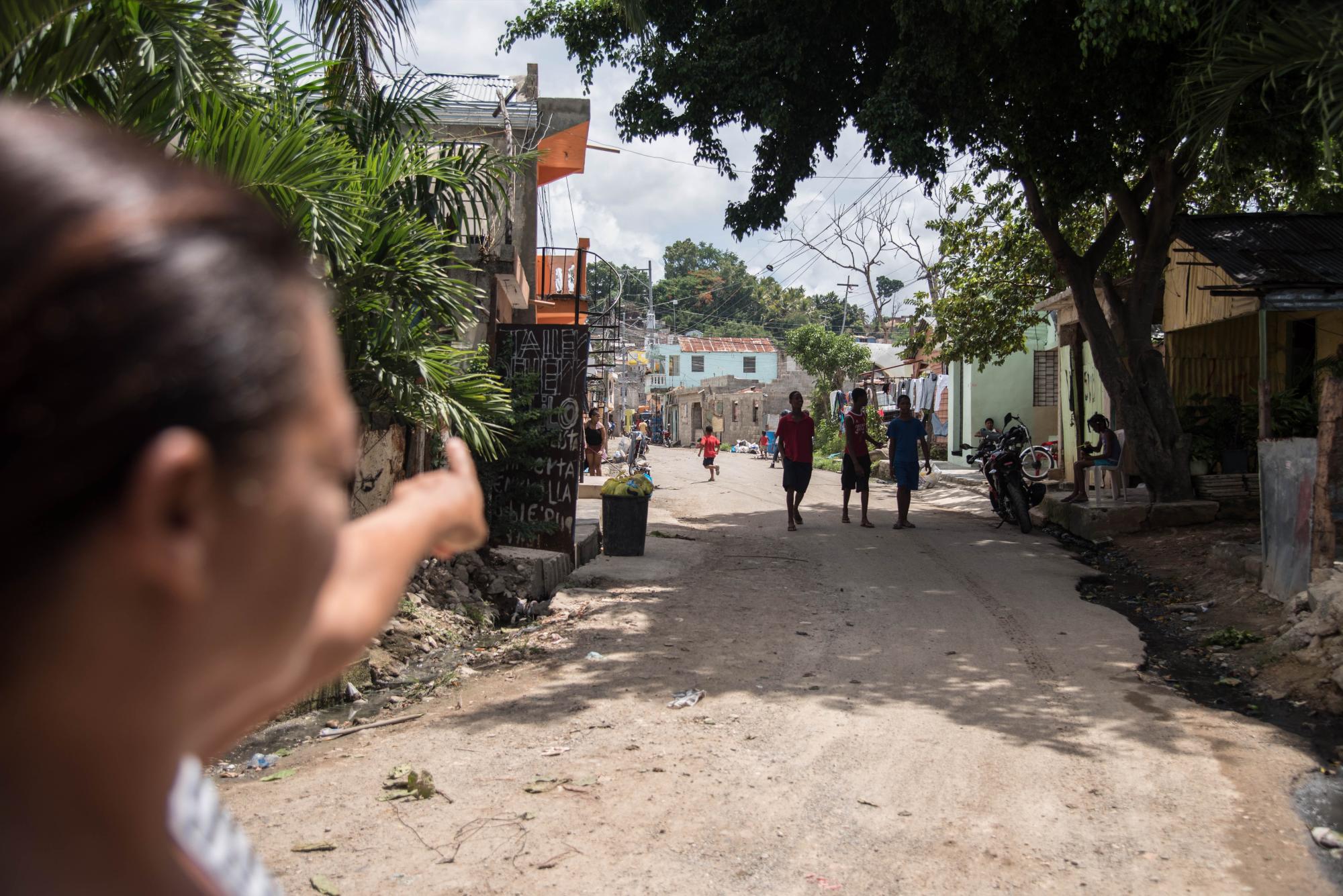 Una mujer señala hasta donde llega el río Ozama en el barrio, Las Lilas