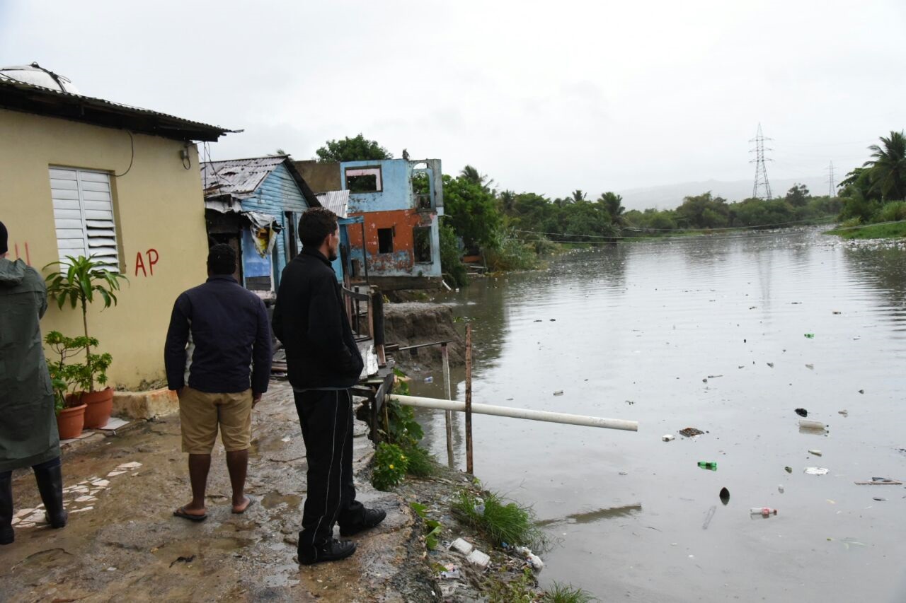 Residentes del sector Aguas Negras o Nuevo Renacer, en Puerto Plata, observan, en un momento que se detuvo la lluvia, el río San Marcos. 