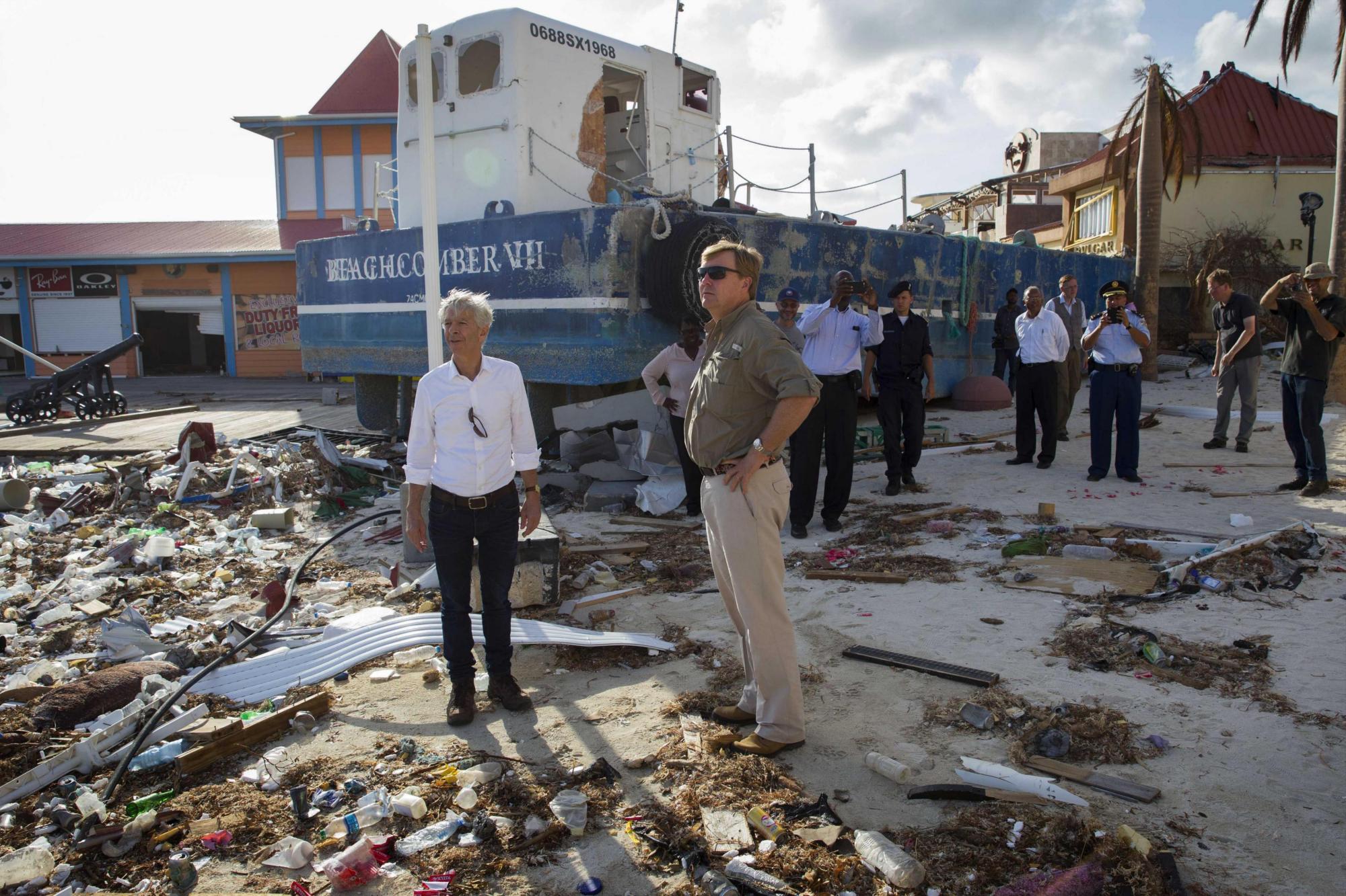 El rey Guillermo-Alejandro de Holanda (c-d), junto al ministro holandés del Interior, Ronald Plasterk (c-i), mientras inspeccionan los daños causados por el huracán Irma en San Martín.