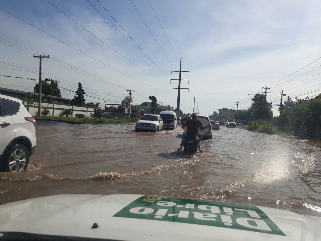 Imagen de la inundación que provocó la rotura de un tubo de agua potable en la autopista San Isidro, casi esquina Charles de Gaulle, lo que causó que se agravara también los tapones por esa zona de Santo Domingo Este.