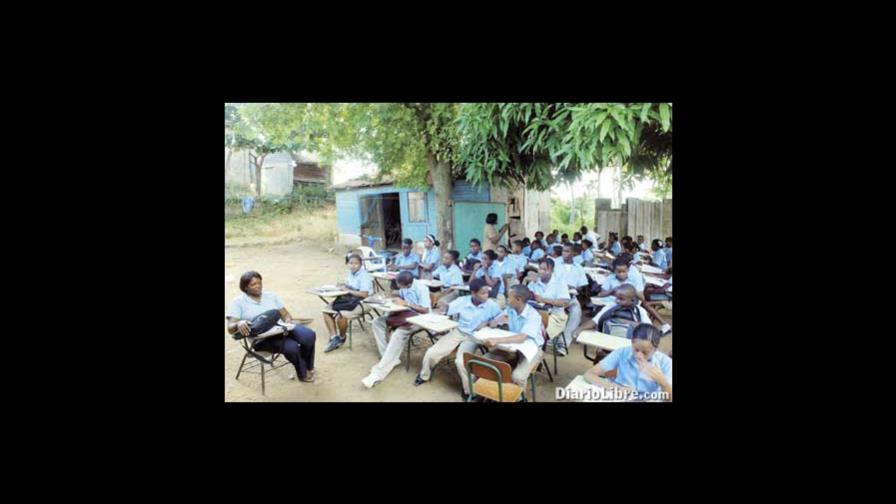 Niños reciben clases al aire libre, frente al sol