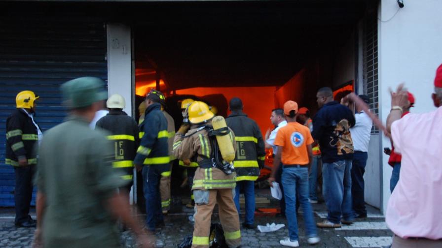 Bomberos tratan de apagar fuego fábrica de Villa Mella