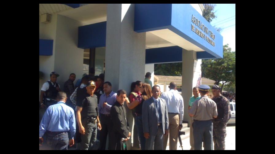 Policías rodean presuntos asaltantes en sucursal bancaria de Santiago