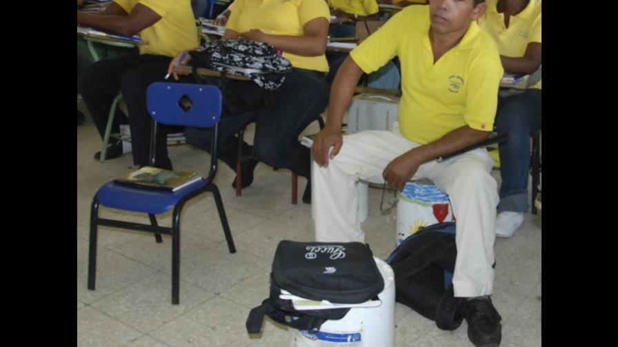 Estudiantes se sientan en latas y en piso escuela