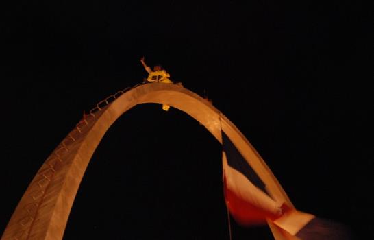 Médico protesta subido en la cima del arco de la Plaza de la Bandera