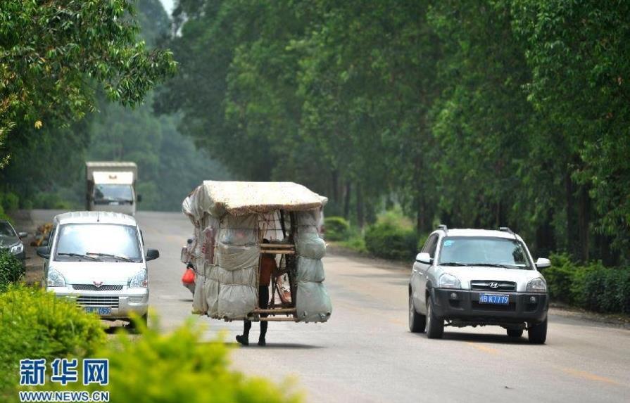 Un hombre caracol viaja por China cargando a cuestas su propia casa
