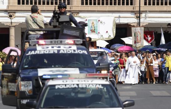 Cura mexicano lucha contra un cártel rosario en alto y con chaleco antibalas