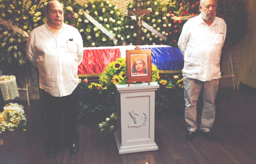 Restos de Sonia, cubiertos con la bandera dominicana y rodeados de amigos y flores