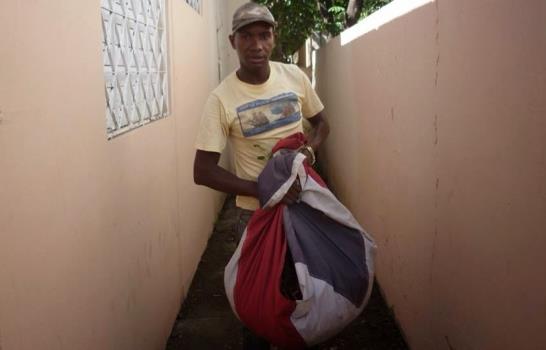 Un empleado público usa la Bandera Nacional como trapo para recoger basura