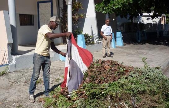 Un empleado público usa la Bandera Nacional como trapo para recoger basura