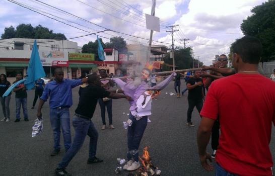 Estudiantes UASD incineran muñeco con foto de Félix Bautista; policías responden con bombas